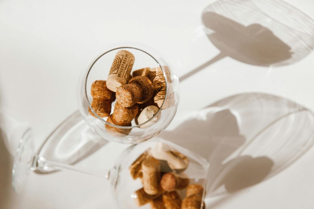 A wine glass full of still and sparkling wine corks