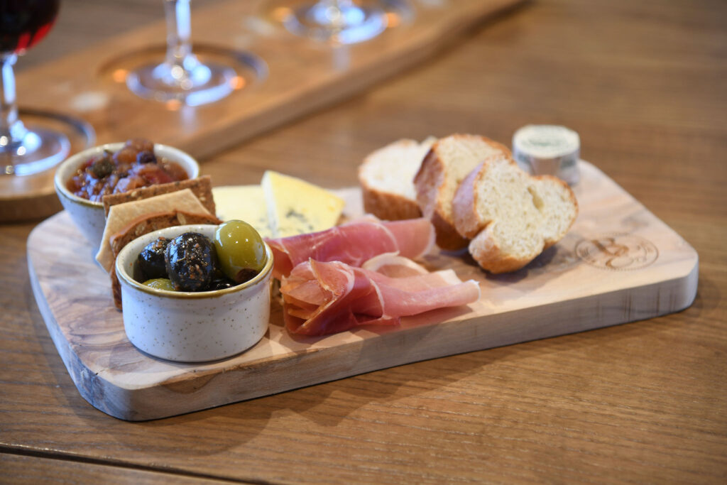 Chacuterie board with ham, olives, cheese, and bread