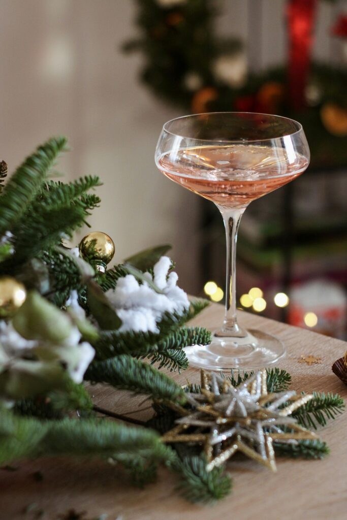 Festive glass of wine with green Christmas decor
