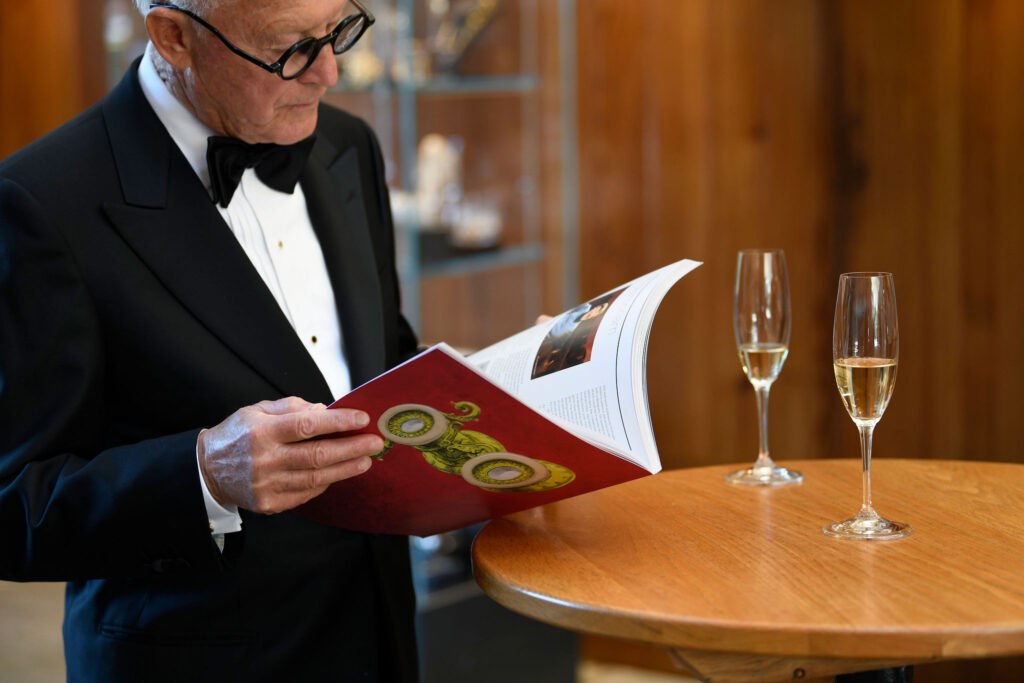 Man reading an opera programme and drinking English sparkling wine