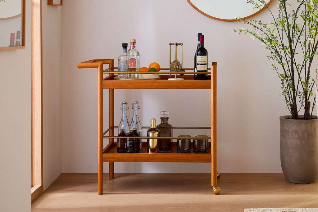 A wooden wine bar cart with wine bottles
