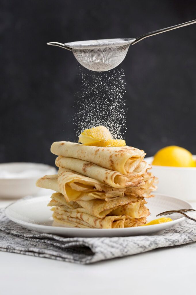 A tower of crepes dusted with icing sugar
