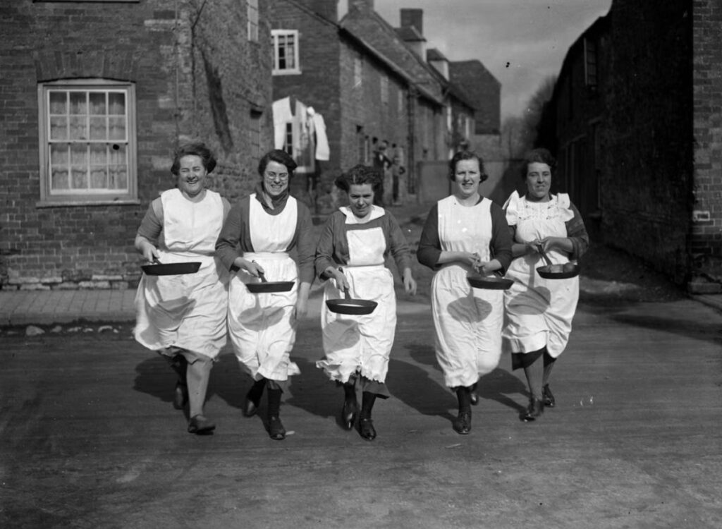 Ladies flipping pancakes in Olney