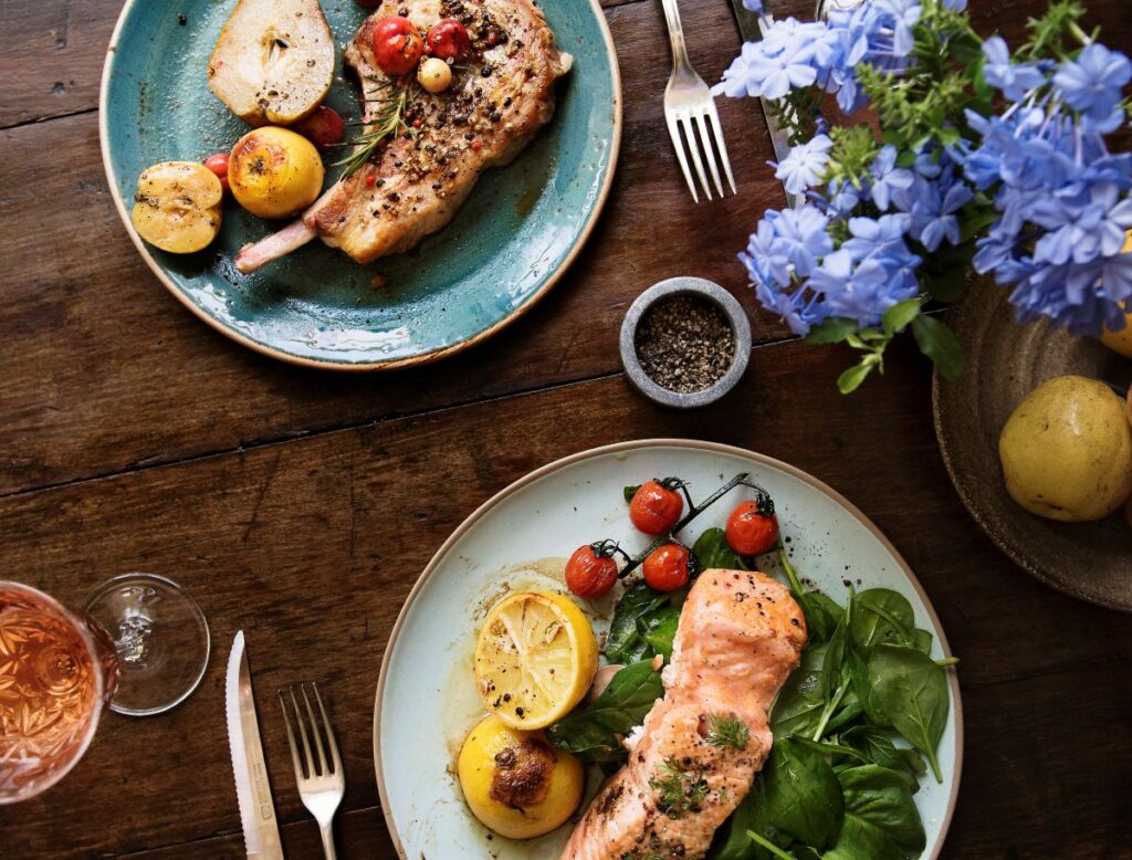 Spring lunch with salmon and steak with blue flowers on the table