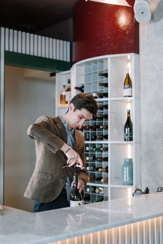 A sommelier opening a bottle of wine