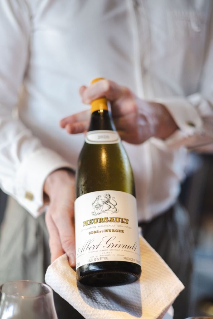 A sommelier showing a guest a bottle of wine before serving