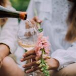 Pouring sparkling wine into a tulip glass with a flower