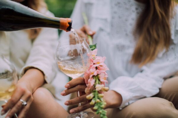 Pouring sparkling wine into a tulip glass with a flower