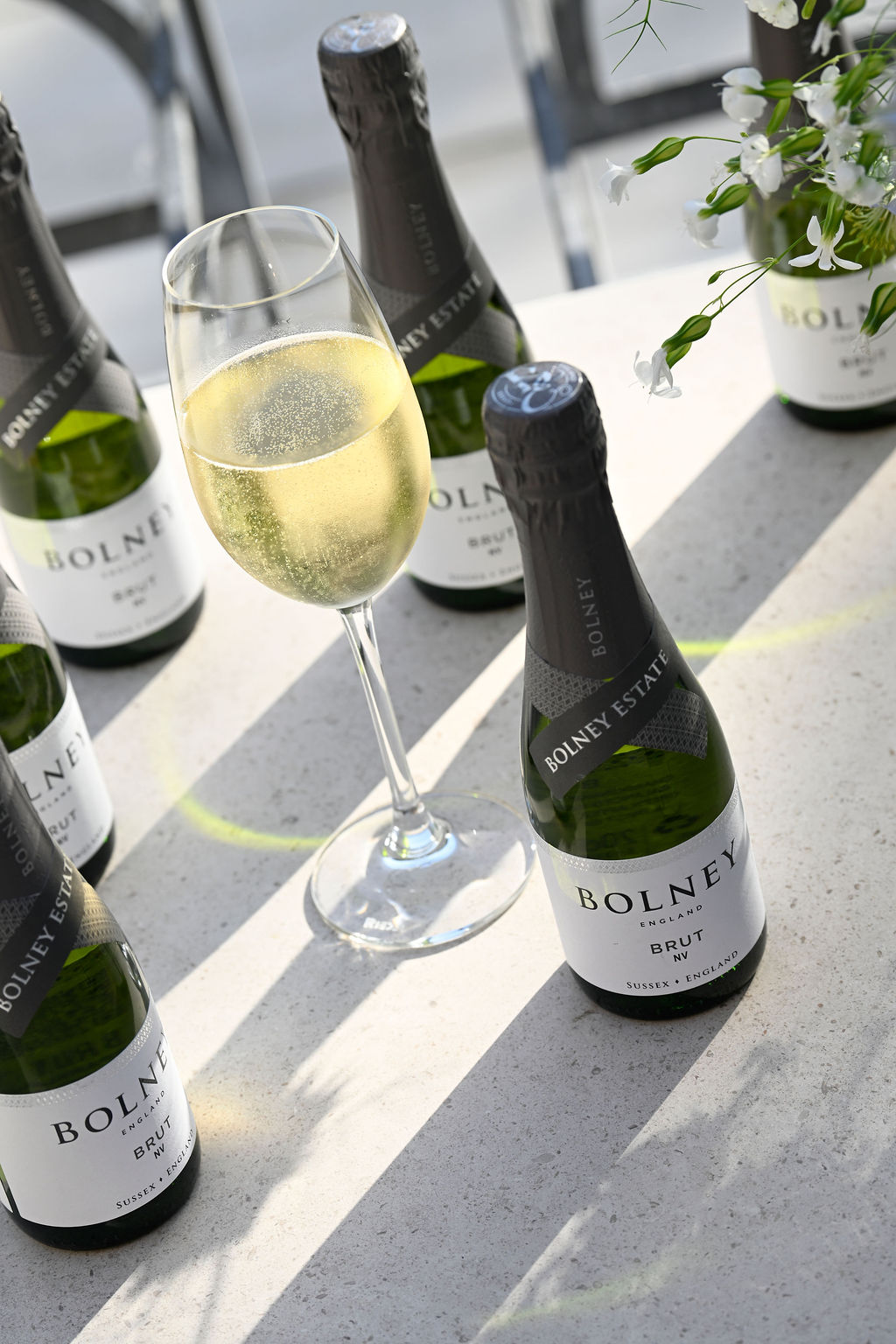 A miniature bottle of Bolney Bubby next to a glass of sparkling wine