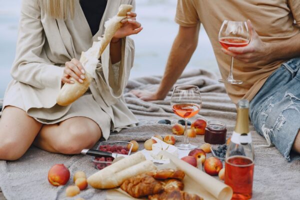 A couple having a summer picnic with rose wine