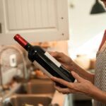 A lady reading a wine label