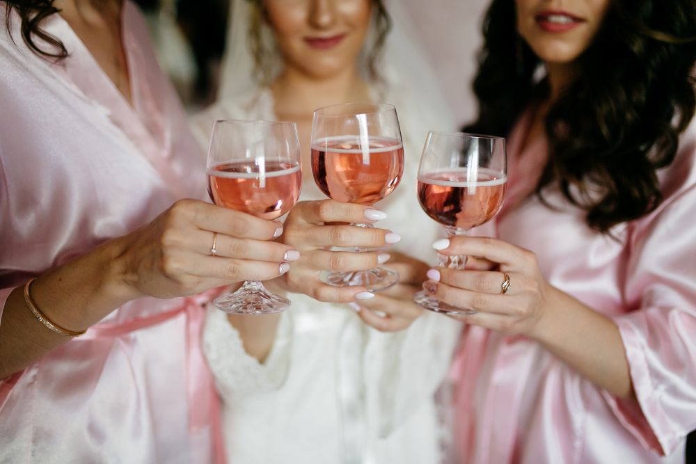 A bridal party drinking rose wine before the wedding