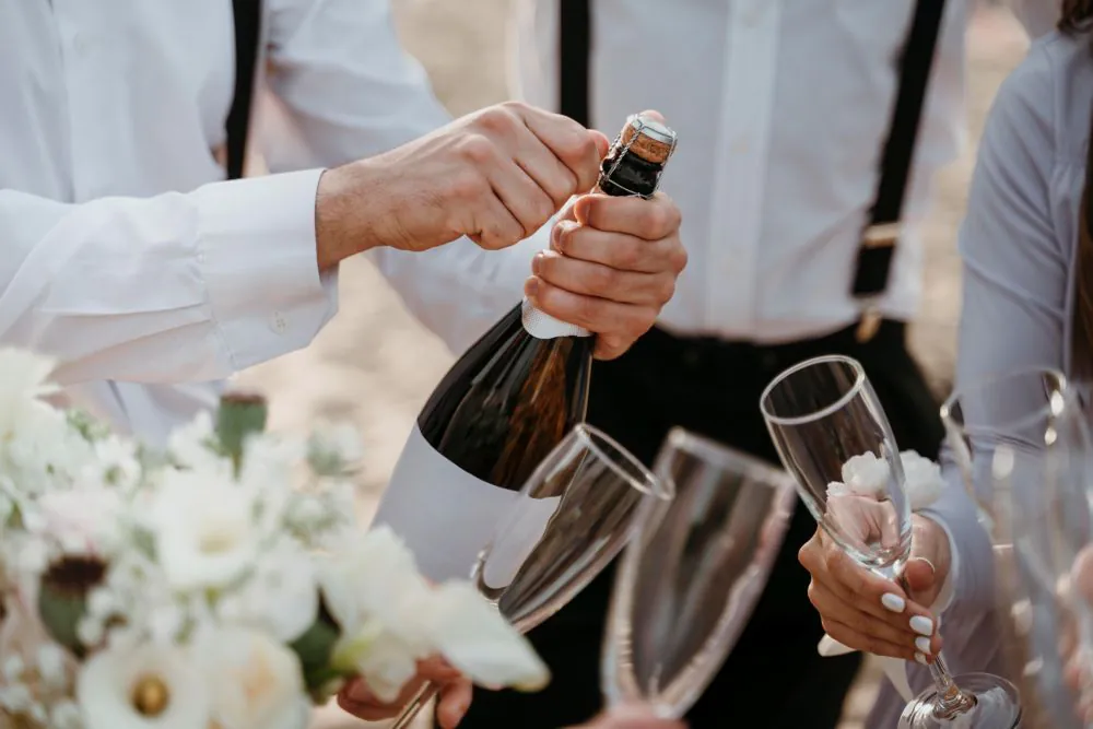 Opening a bottle of English sparkling wine at a wedding