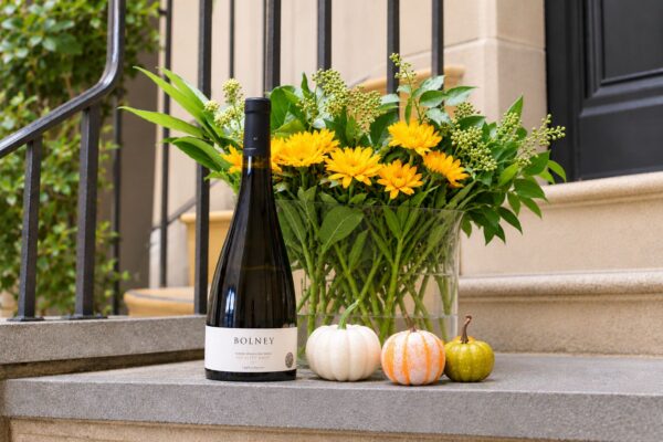 Bolney orange wine 2023 beside flowers and pumpkins