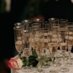 Sparkling rose wine in flutes beside a rose